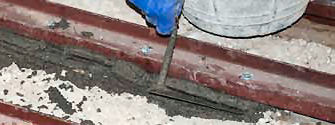 Enchimento entre a vigota e a peça metálica de reforço, com argamassa de cimento, confeccionada em obra, com aditivo hidrófugo, dosificação 1:3